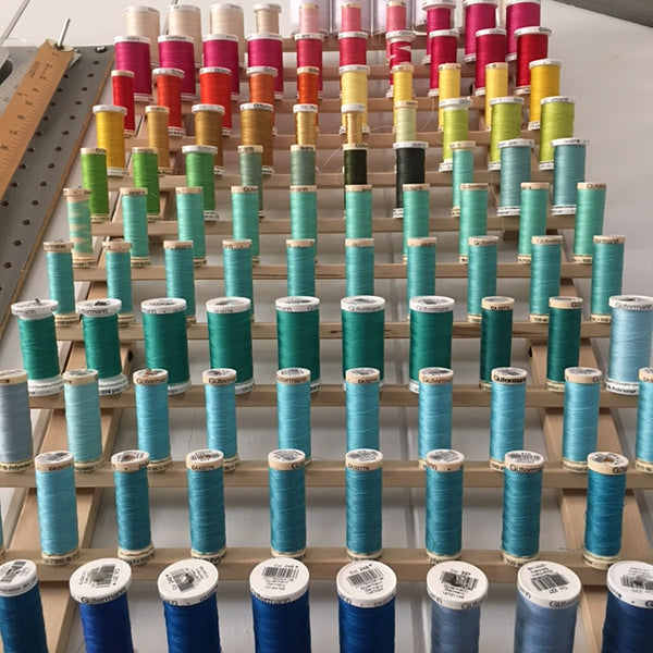 Thread rack with a rainbow of sewing thread