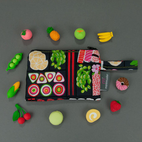 Bento Box Reusable Snack bag with little fruit erasers around it on a grey background