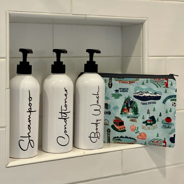 image of Marshmueller Zipper Pouch in I Heart Oregon print next to shampoo bottles in a tiled background