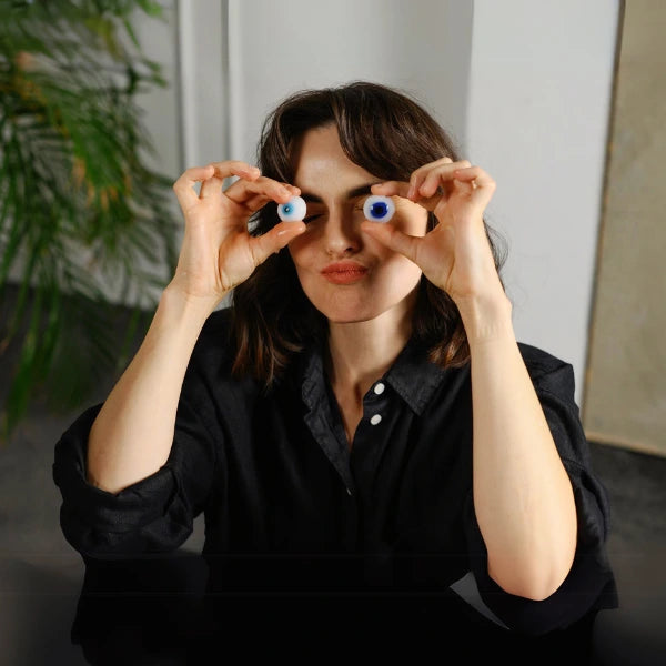 Person playfully holding fake eyeballs in front of their eyes.