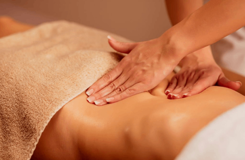 masseuse is giving back massage with massage oil 