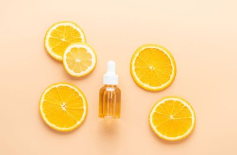 Vitamin c face serum with oranges are on table