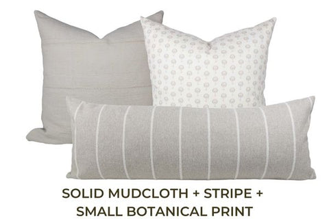 Three throw pillows in varying tones of grey and white