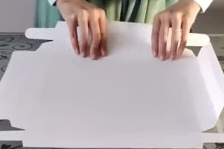 Hands folding a white paper bake box