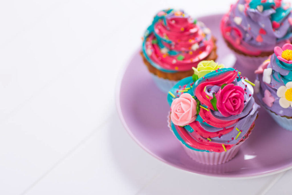 Colorful cupcakes with decorative frosting and sprinkles.