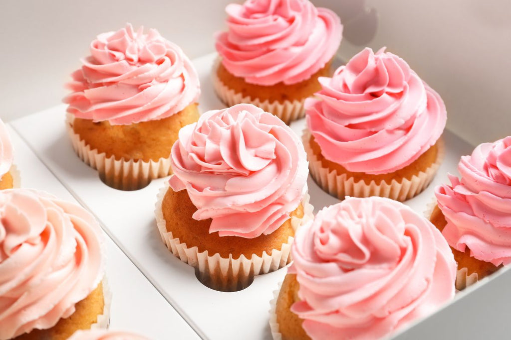 Pink frosted cupcakes arranged on a plate.