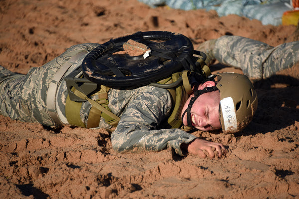 366th Training Squadron explosive ordnance disposal student, performs a 45-pound weighted low crawl through a sand pit during the EOD preliminary course