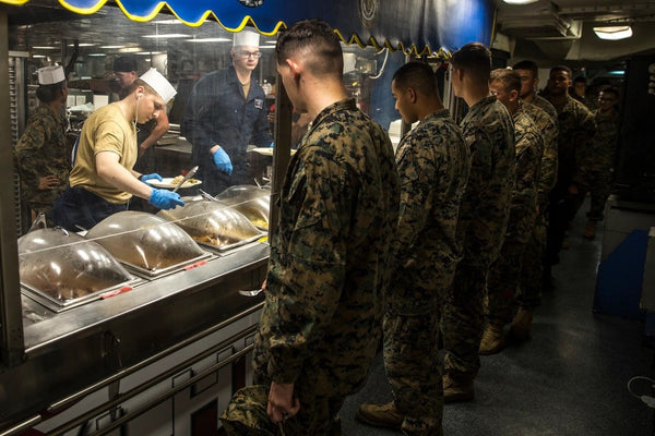 Marines and Sailors provide food to ship’s personnel