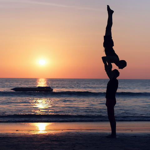 standing acroyoga at sunset