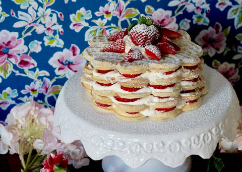 A tower of 5 layers of waffles, strawberries, and whipped cream