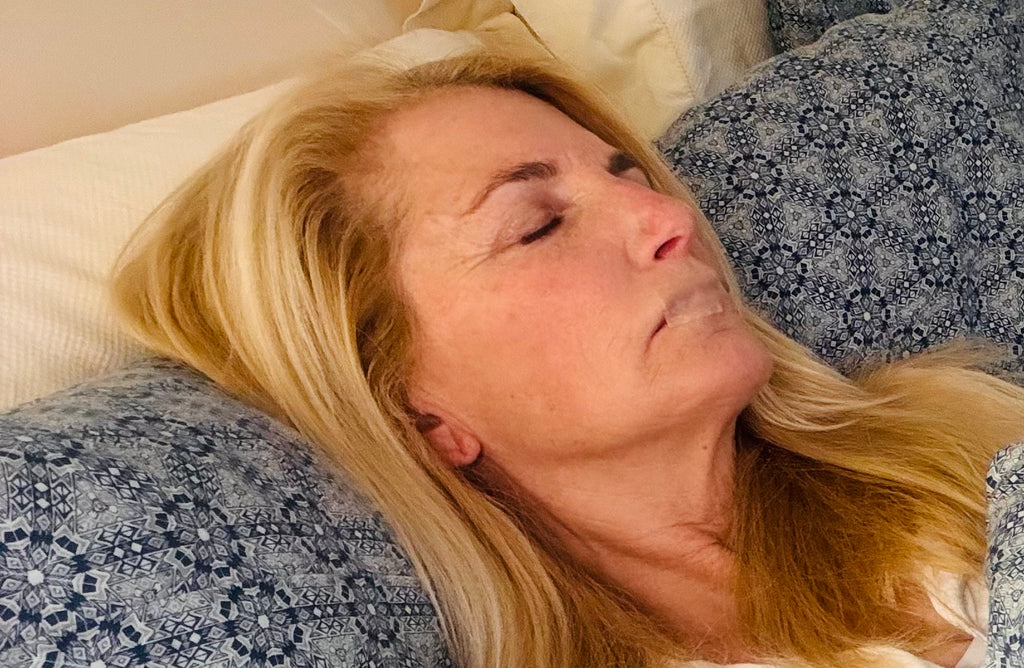 口をテープで閉じて眠っている人の画像。鼻呼吸を促進し、睡眠の質を向上させるテクニックを示しています。