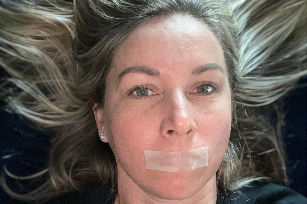 Image of a girl with mouth tape applied, showcasing the technique to encourage nasal breathing and improve sleep quality by preventing mouth breathing during the night.