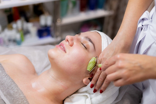 Image of hands massaging a face with natural oils, illustrating the technique for enhancing skin health and reducing wrinkles through facial massage.