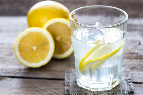 A glass of alkaline water with ice and lemons