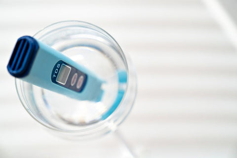 A blue device in a glass of water