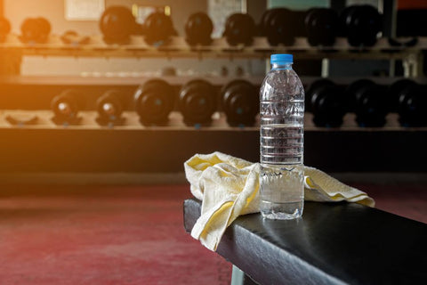 A bottle of water and towel on a table