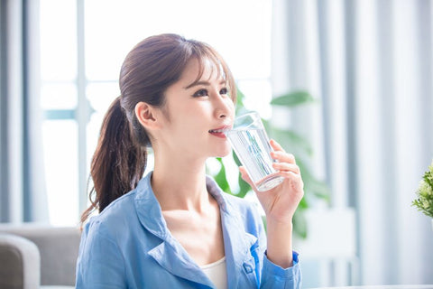 A person drinking water from a glass