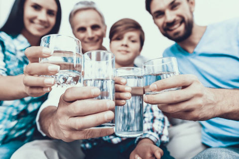 A group of people holding glasses of water