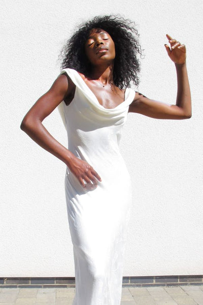 A model wears a Sabina Motasem wedding dress with a cowl neck wedding dress neckline