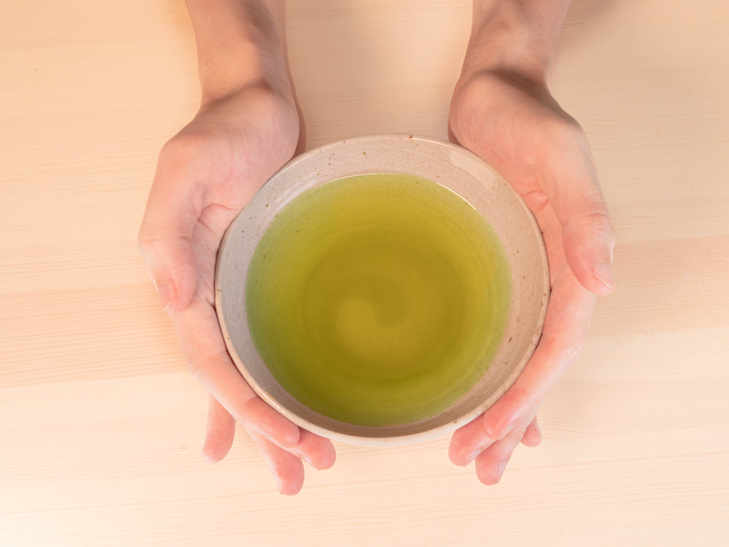 Holding brewed genmaicha in cup