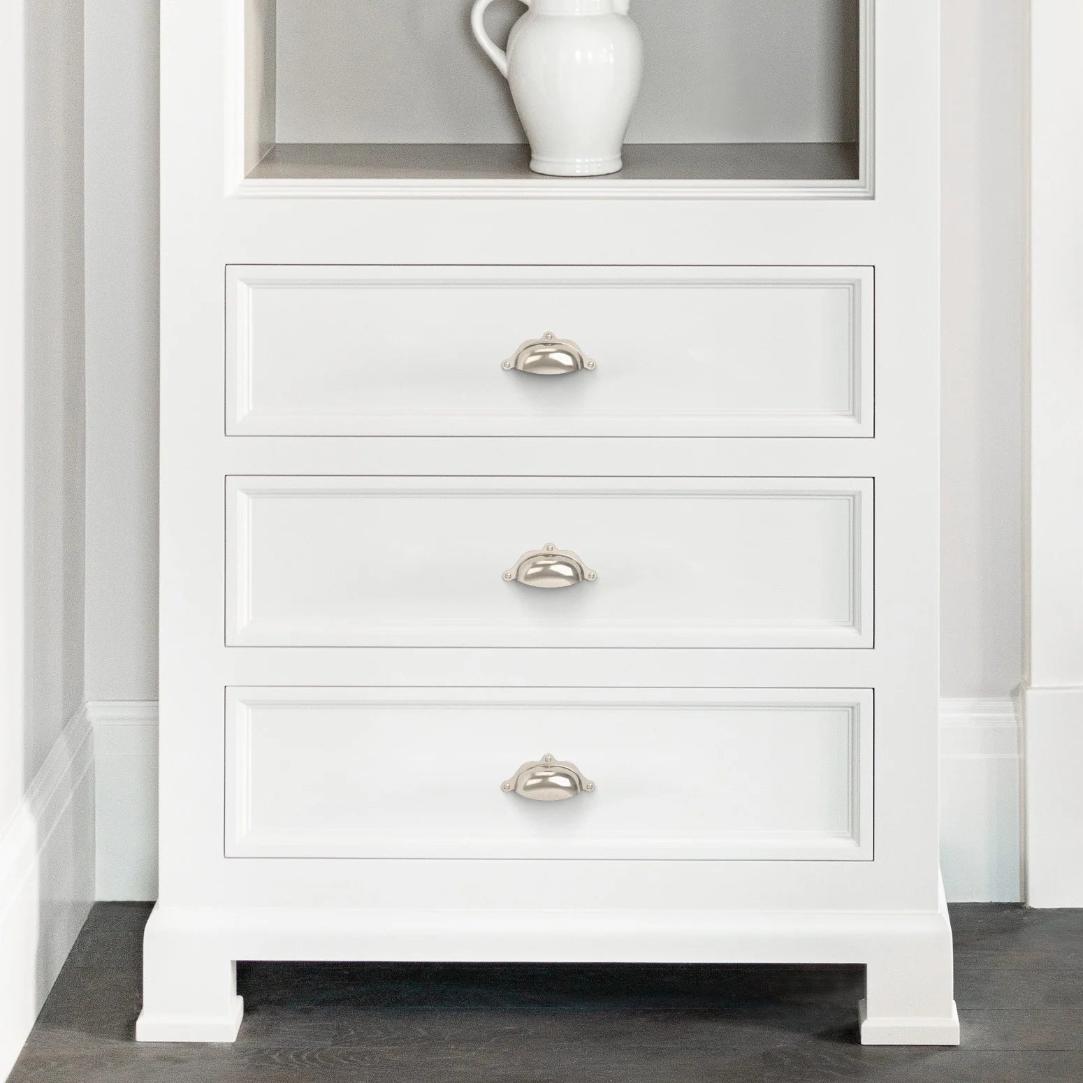 White wooden drawer cabinet with silver cup pull handles in a contemporary home setting