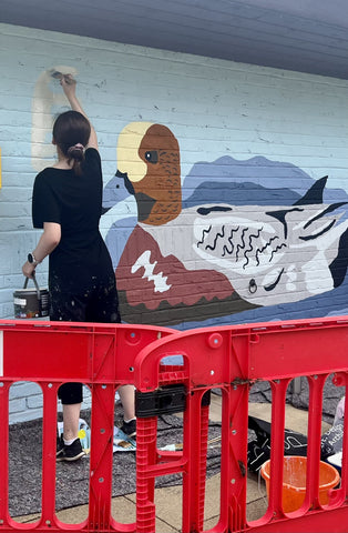 Beth Morgan painting a duck as part of her mural
