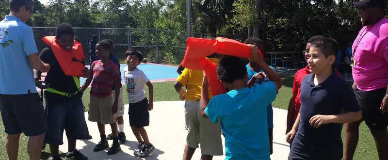 kids learn how to put on a life jacket