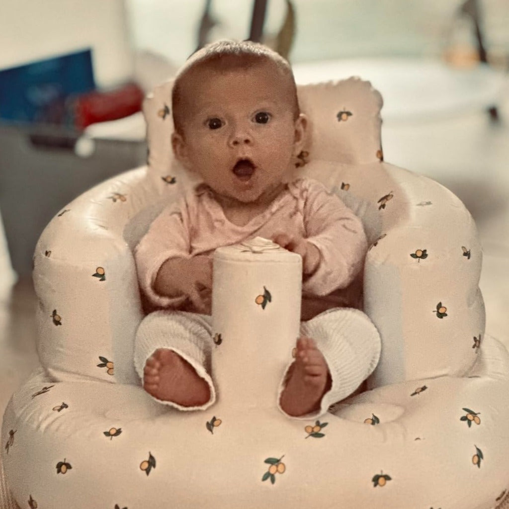 Baby sitting upright in a fruit inflatable baby sit up chair — supportive seat for infants learning to sit unassisted