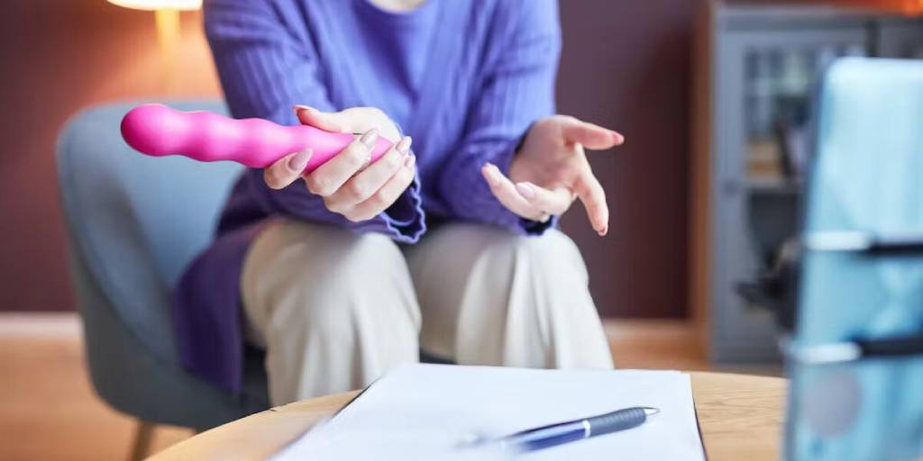 femme qui inspecte son vibromasseur rose