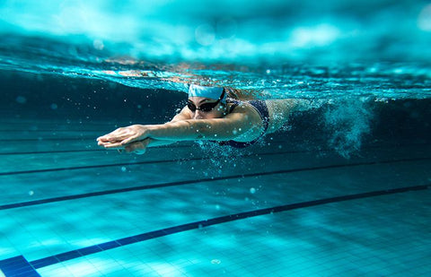 woman experiencing menopause joint pain swimming in a pool as a low-impact physical activity that is easy on her joints