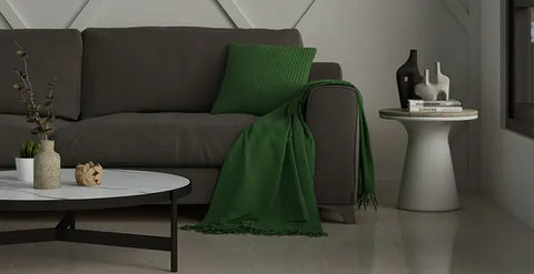 dark grey sofa with green cushions 
