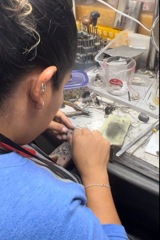 woman at workbench using jewelry tools