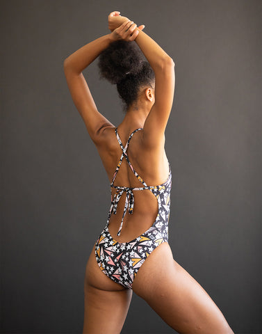 a woman wearing a JOLYN breast cancer one piece swimsuit