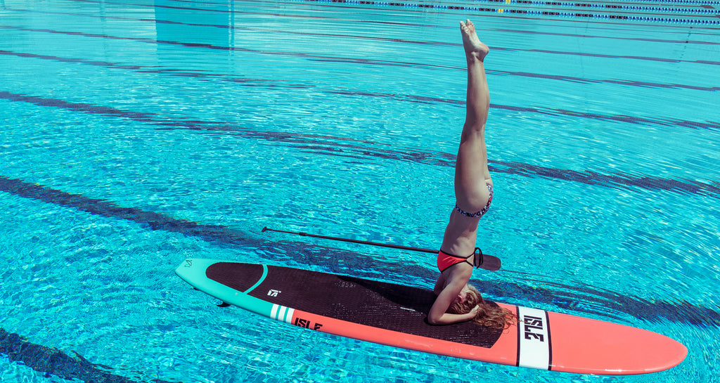 women on a paddleboard wearing JOLYN swimsuits