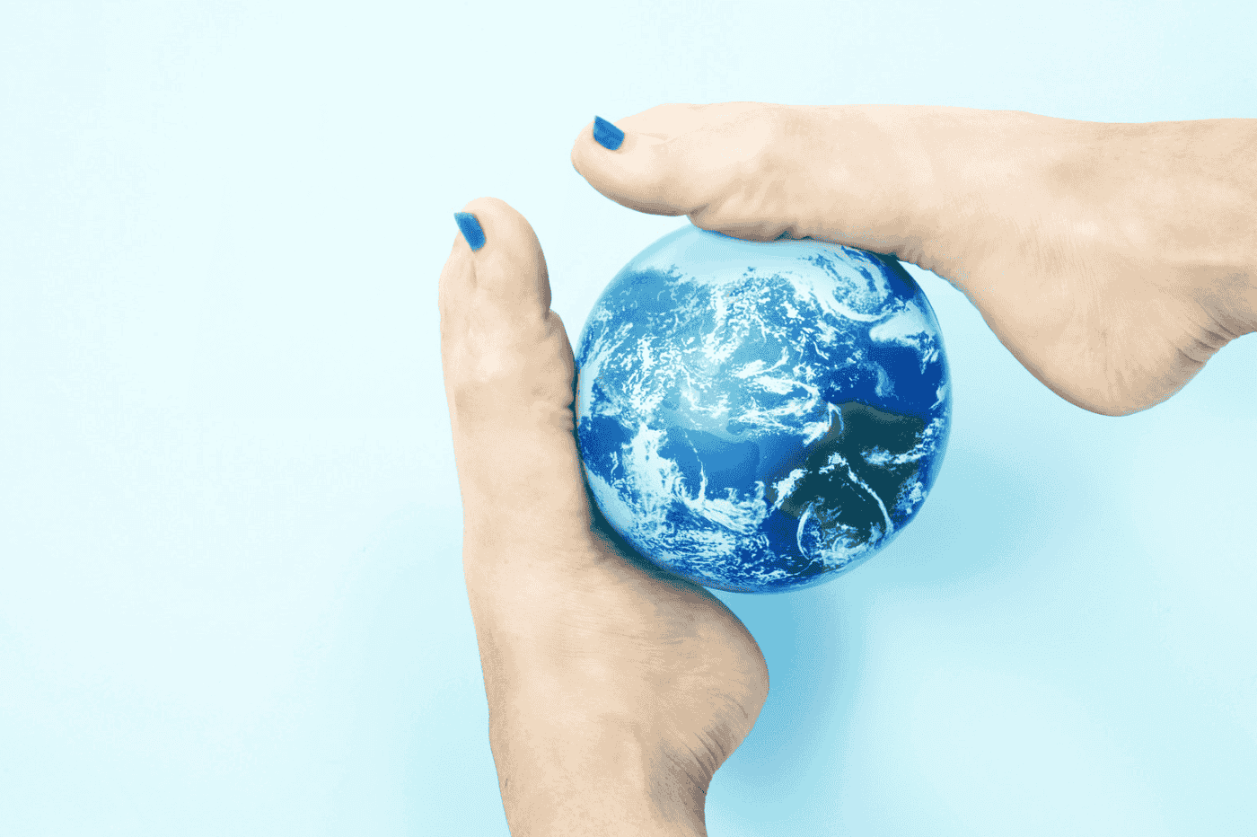 Feet holding the planet Earth