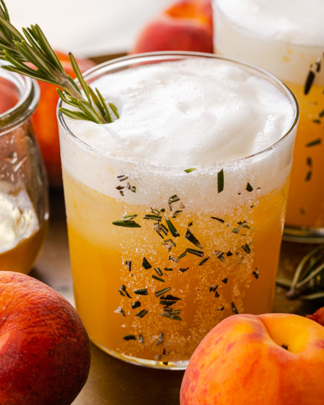 An alcohol-free recipe for peach rosemary mocktails, made with homemade rosemary simple syrup and fresh egg whites. | peteandgerrys.com