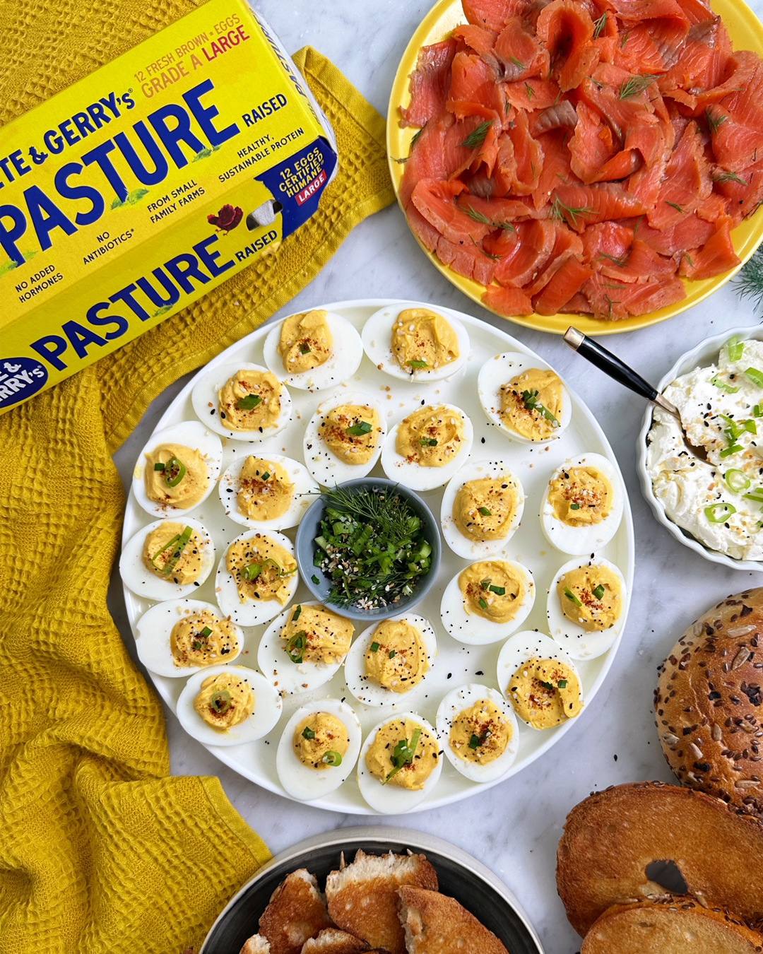 A party platter of deviled eggs prepared with pasture-raised eggs, everything bagel seasoning, and buttered bagel pieces. | peteandgerrys.com