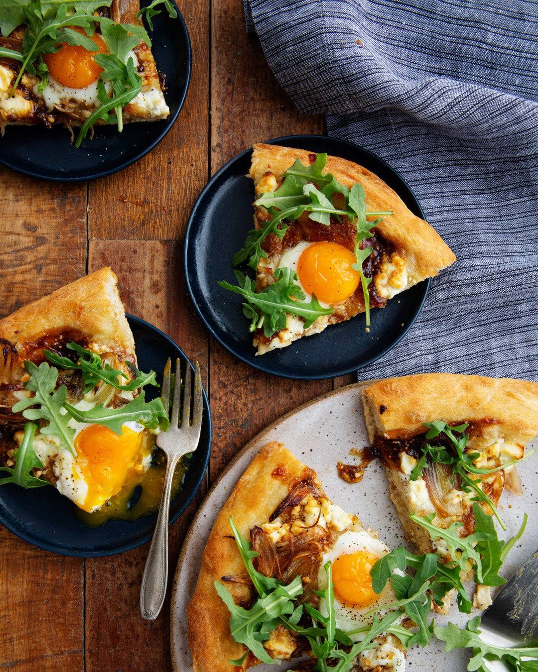 A sunny breakfast pizza topped with fig preserves, arugula, goat cheese, and eggs with runny yolks. | peteandgerrys.com