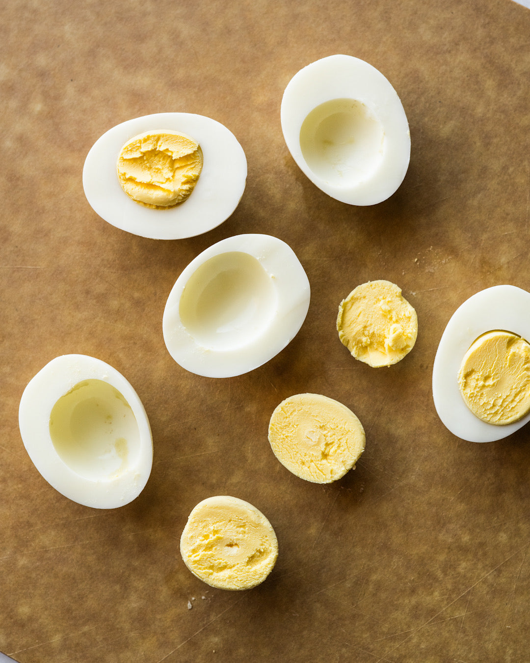 Sliced hard-boiled eggs arranged on parchment paper to show perfectly cooked whites and yolks. | peteandgerrys.com