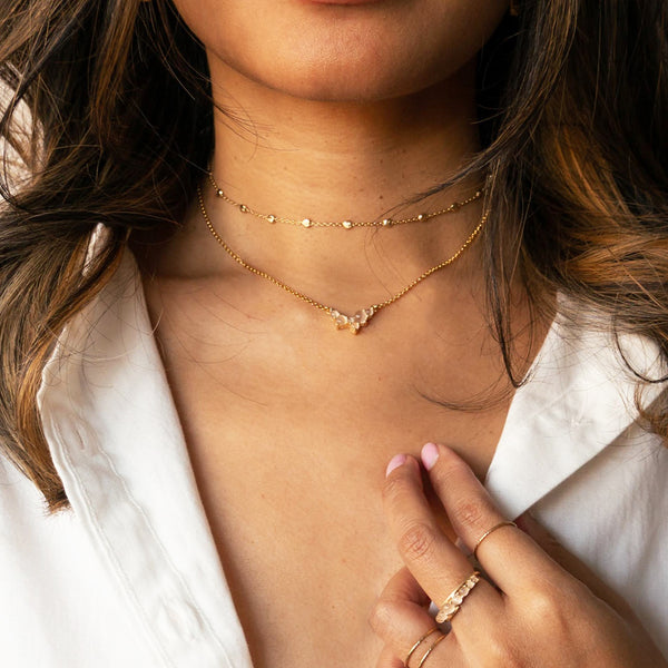 img of woman wearing a gold choker and peach moonstone pendant