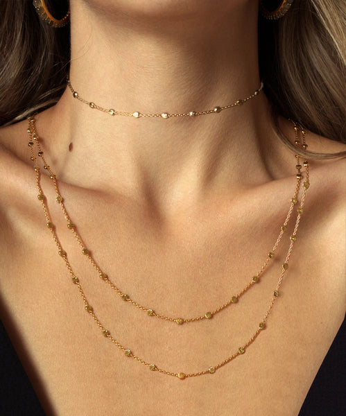 woman wearing layered gold necklaces