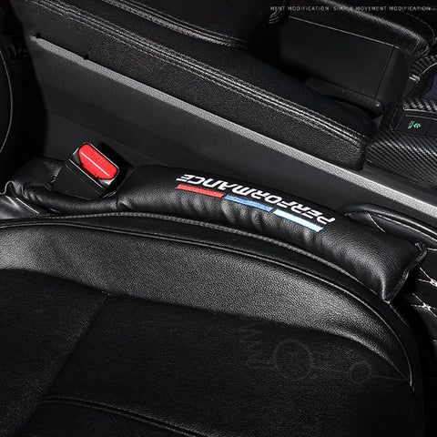 Sleek car seat gap filler in black, branded with 'FashionAuto' in bold white, red, and blue, nestled between a leather car seat and center console. This practical accessory helps prevent items from falling through the seat gap, maintaining a clean and organized vehicle interior. A must-have car organization tool, available now at OnlineFamStore.com.