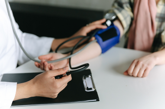 doctor taking a persons blood pressure