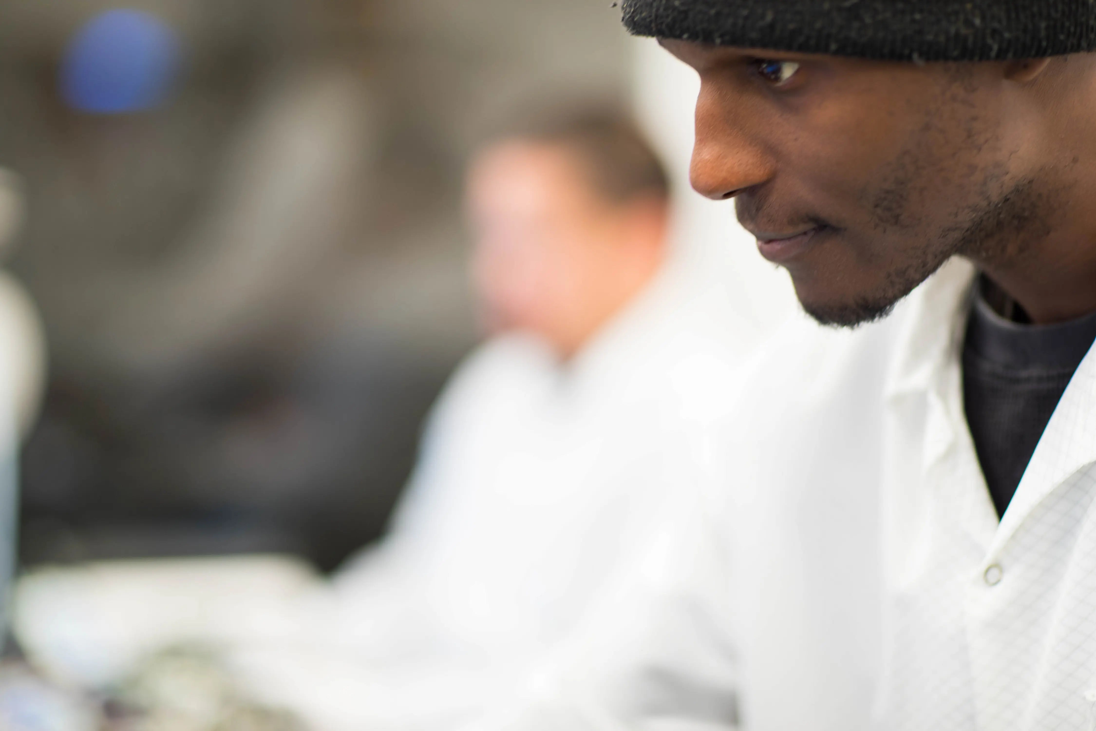 A guy with small stubbles on his chin, focusing on his task