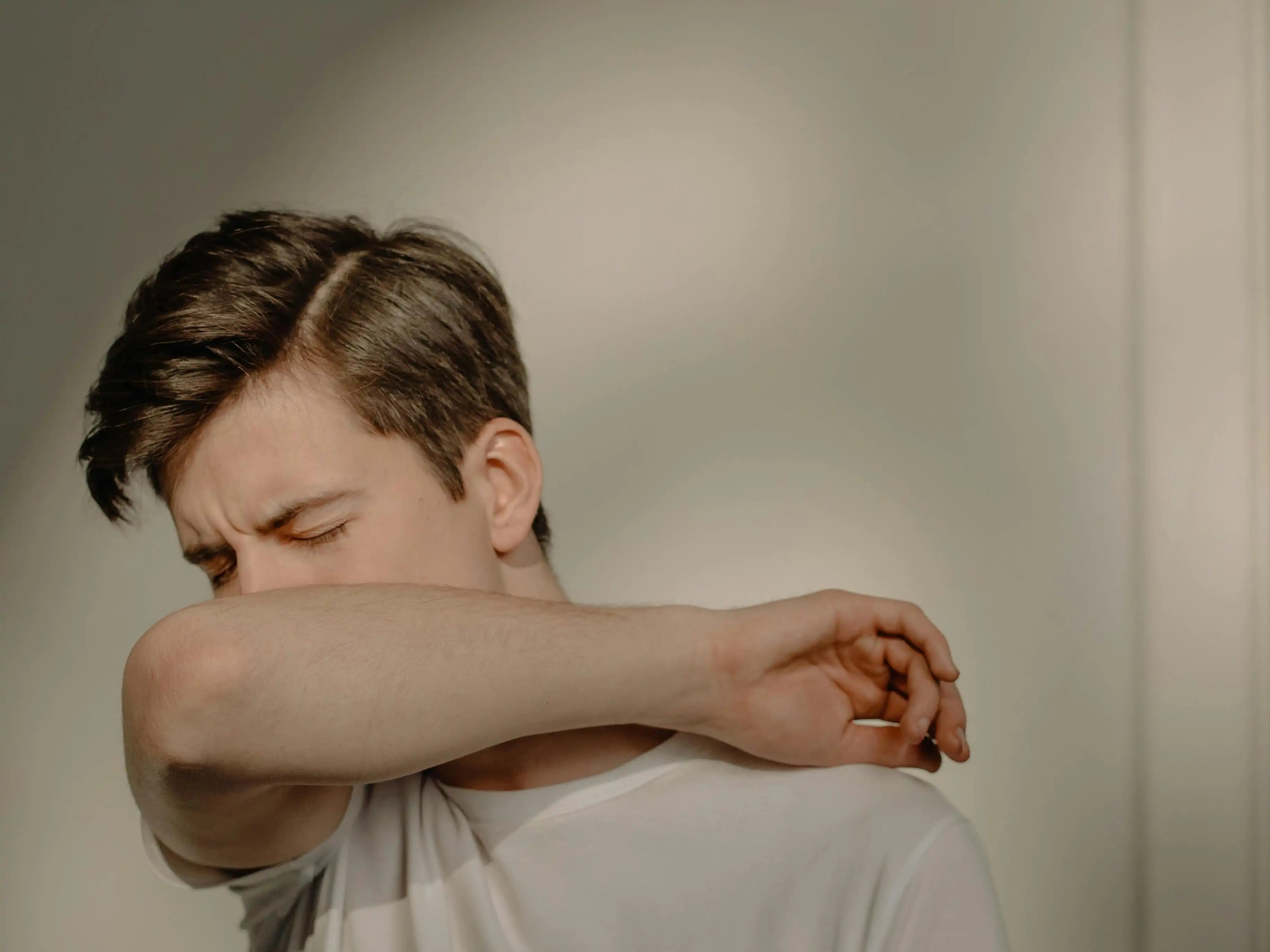 A man with sinus infection covering his mouth