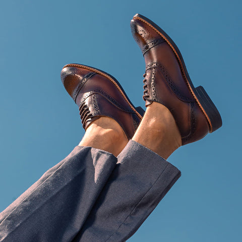 The image shows a man with his legs up, wearing a Dress Shoes OXford Sandro Moscoloni Premium