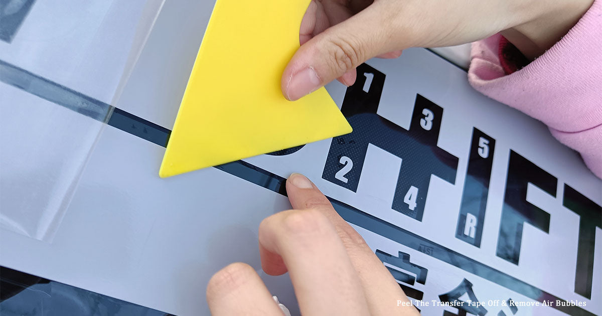 Close-up of using a squeegee to scrape out air bubbles under the decal