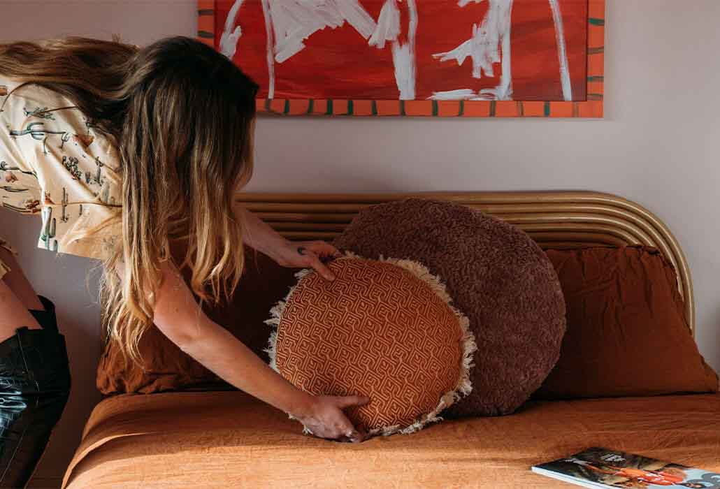 Image of Emma Jane Palin adjusting a cushion in the bedroom