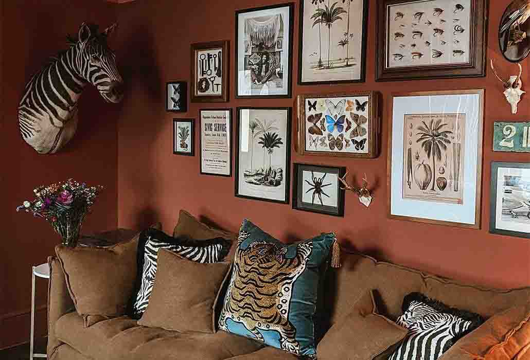 image of Alice @strikemepink's red living room with gallery wall above the sofa