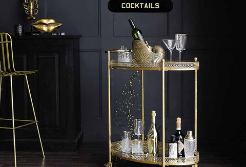 image of a gold drinks trolley styled with cocktail glasses and barware